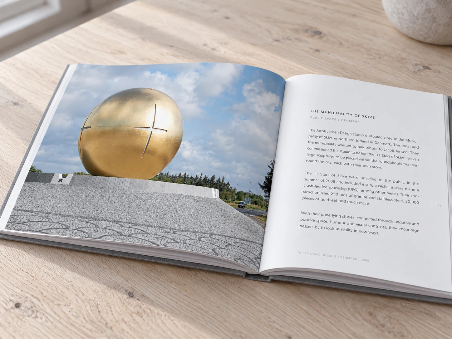 Åben Jacob Jensen Design-bog med opslag om den gyldne skulptur i Skive